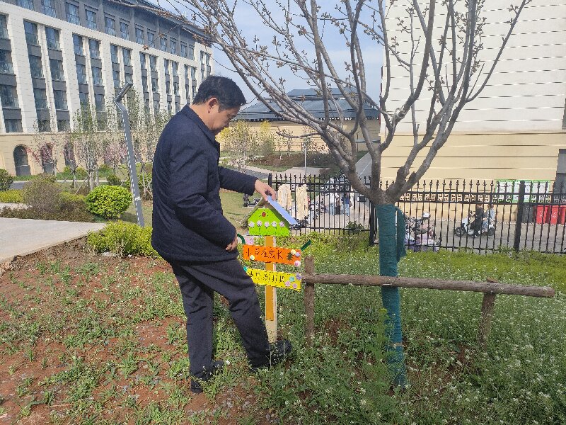 1783383655098017061.jpg 王院长在乐知社区楼前插牌.jpg